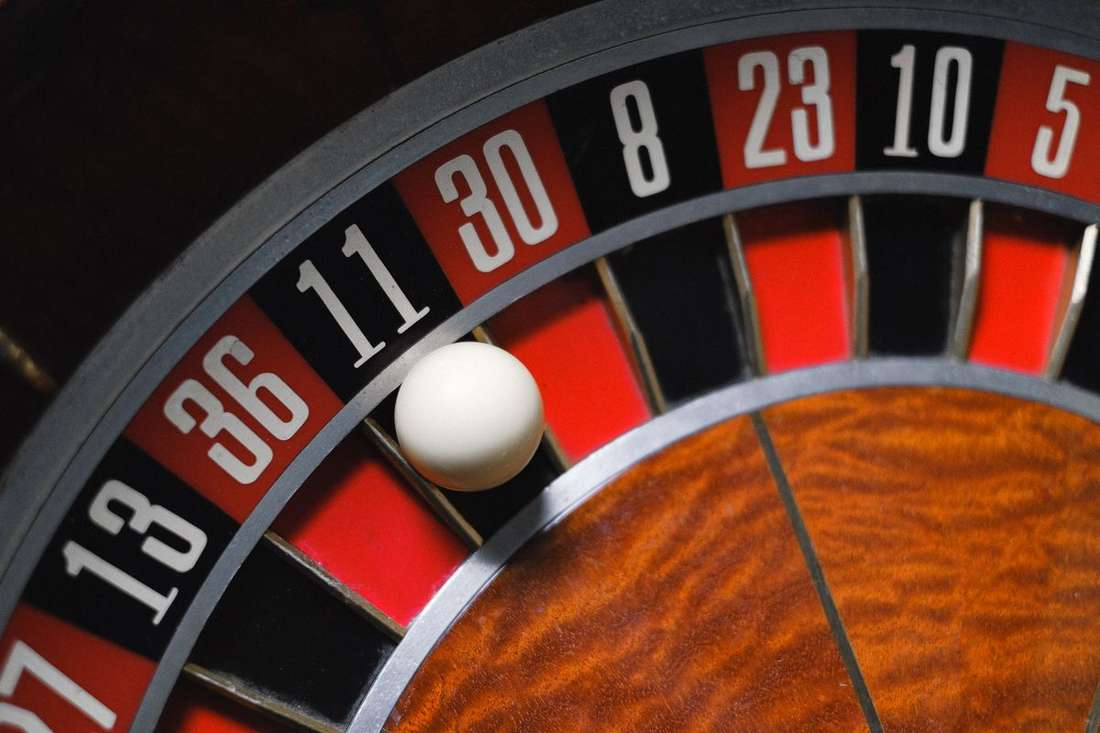 Roda roulette dengan bola kecil di atas meja kasino