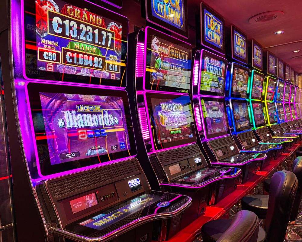 Barisan mesin slot bercahaya warna-warni di kasino